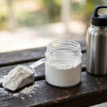 Creatine for fat loss: creatine monohydrate scoop and supplement jar beside a gym water bottle