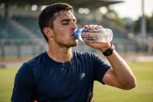 Athlete drinking from a sports bottle during training — hydration for athletes